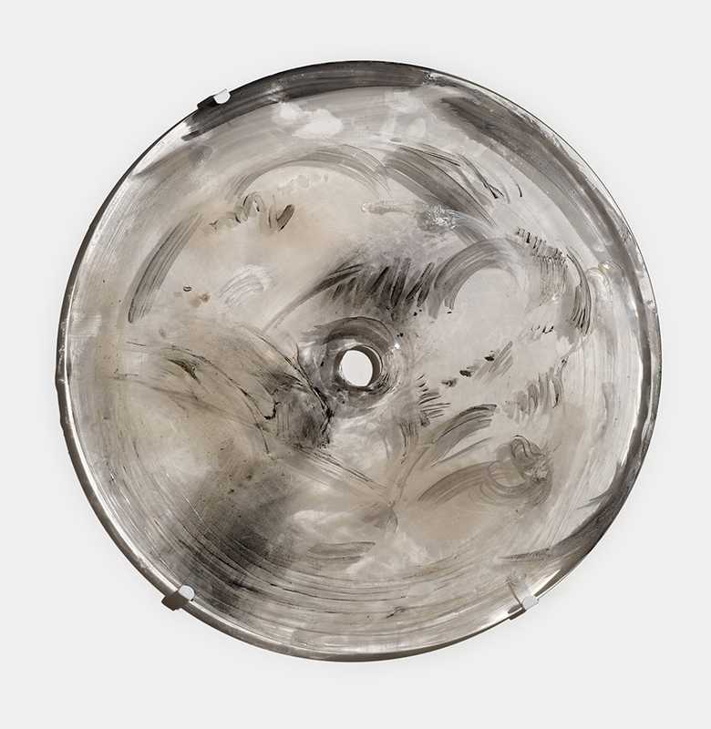 *Gong Piece*, 2024; glass, rondel, chalk, charcoal, pigment, dust, metal; 24 x 22 x 1 inches